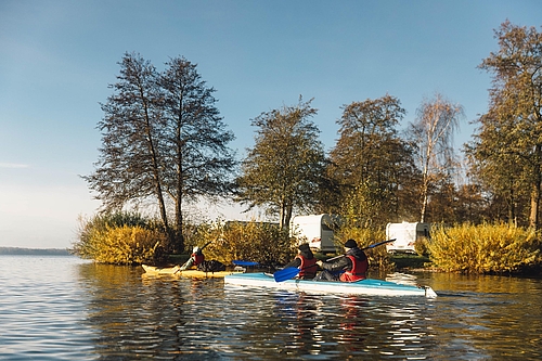 Kayakfahrer mit Wohnwagen im Hintergrund