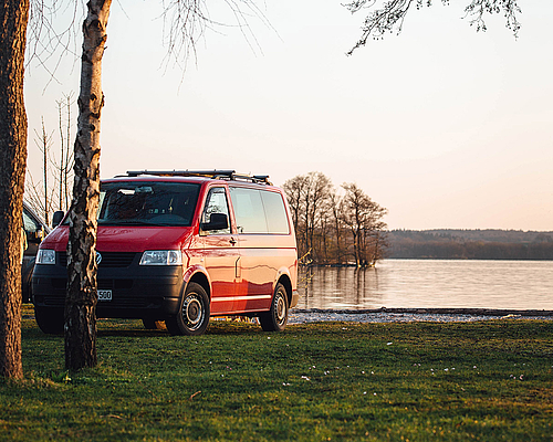 Roter Campingbus direkt am See