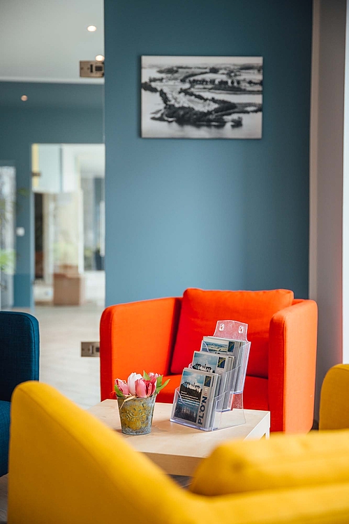 Foto der Sitzecke der Rezeption mit bunten Möbeln